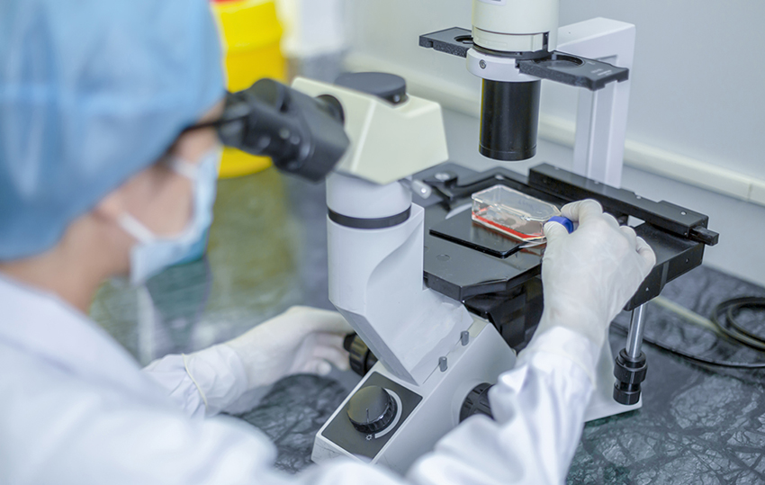 scientist with microscope doing research