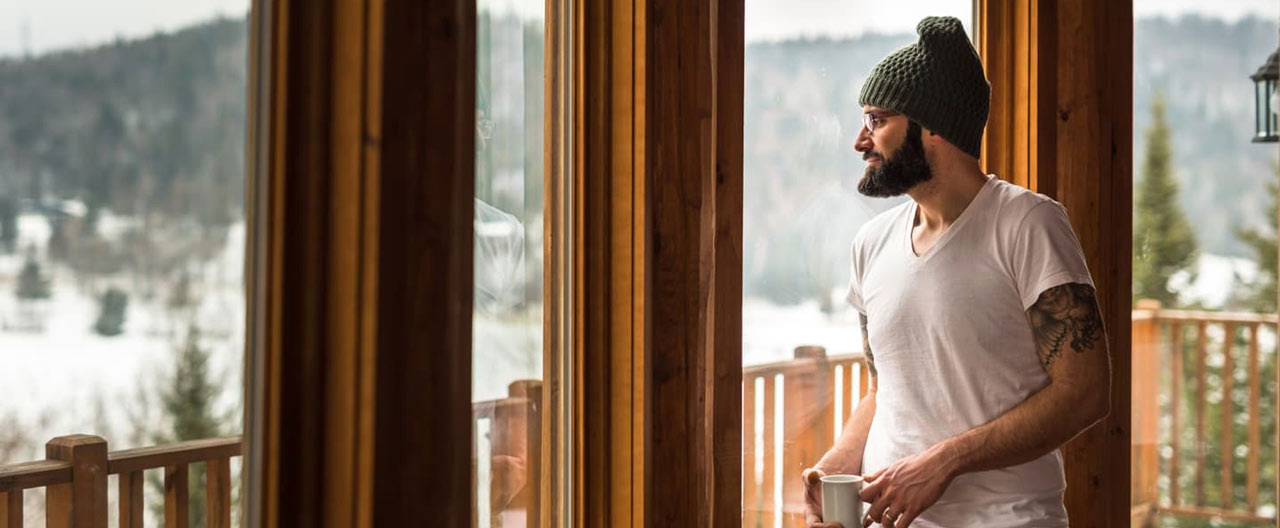 man watching the snowy view inside