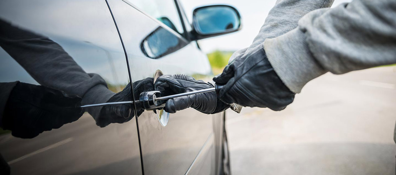 thief breaking into car door