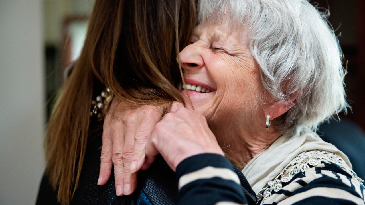 elderly mother hugging daughter